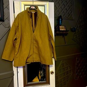 Man jacket is a khaki color with a zipper and it's made by fear of God.